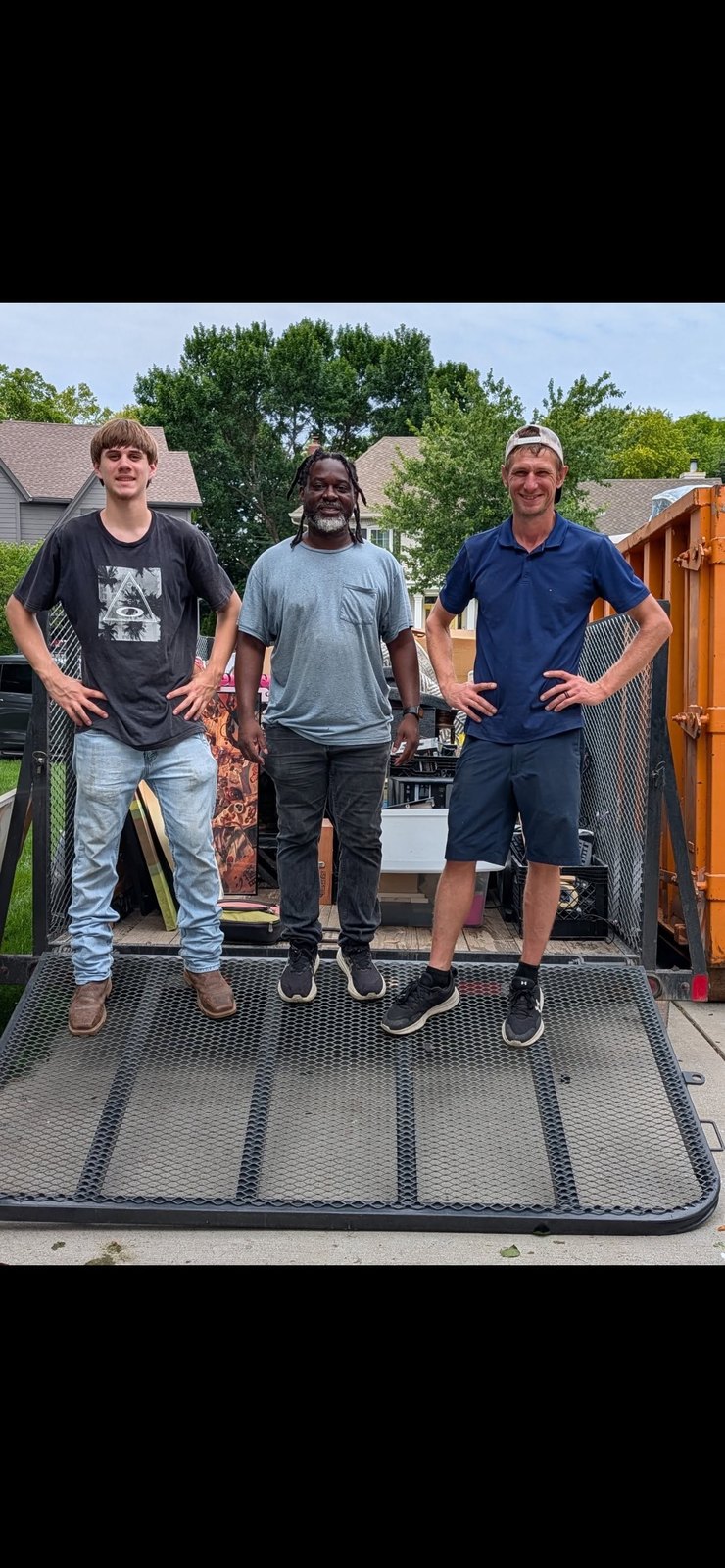 Derek's Removal Services team standing on a trailer after a job